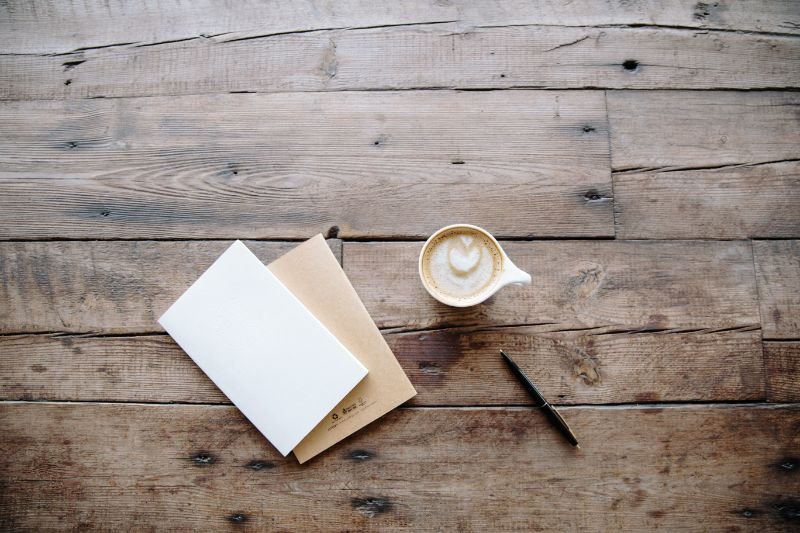 A blank notebook and pen on a desk, symbolizing the beginning of the writing journey and the potential for creative inspiration